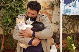 محمد يحتضن القطط في المحمية كالأطفال.