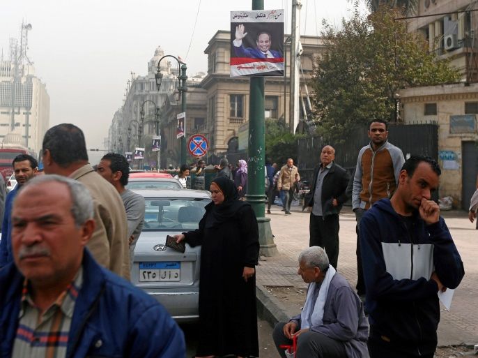 Egyptians wait for the bus near a poster with an image of Egypt's President Abdel Fattah al-Sisi for the upcoming presidential elections, in Cairo, Egypt February 8, 2018. The poster reads:
