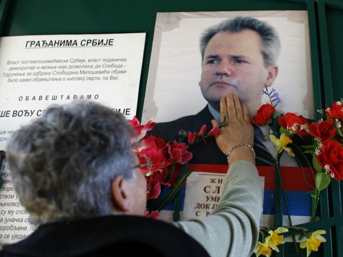 A supporter of Slobodan Milosevic touches his picture at the former president's grave in Pozarevac March 11, 2008. Admirers of the late Serbian strongman gathered on Tuesday to hold a memorial ceremony to mark the 2nd anniversary of what they call his