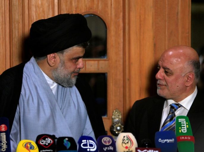 Iraqi Shi'ite cleric Moqtada al-Sadr, who's bloc came first, looks at Iraqi Prime Minister Haider al-Abadi, who's political bloc came third in a May parliamentary election, during a news conference in Najaf, Iraq June 23, 2018. REUTERS/Alaa al-Marjani