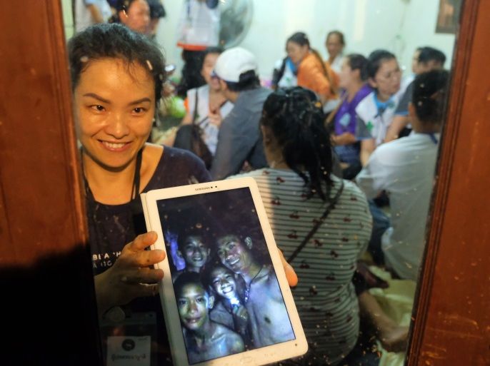 CHIANG RAI, THAILAND - JULY 2: Relatives of the missing boys show photos of them after the 12 boys and their soccer coach have been found alive in the cave where they've been missing for over a week after monsoon rains blocked the main entrance on July 02, 2018 in Chiang Rai, Thailand. Chiang Rai governor Narongsak Osatanakorn announced on Monday that the boys, aged 11 to 16, and their 25-year-old coach were being rescued from Tham Luang Nang Non cave after they were d