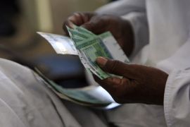 A man counts notes after receiving the new Sudanese currency at a central bank branch in Khartoum July 24, 2011. Sudan on Sunday started circulating its new currency, the central bank said, days after South Sudan started rolling out a currency of its own. REUTERS/ Mohamed Nureldin Abdallah (Sudan - Tags: POLITICS BUSINESS)