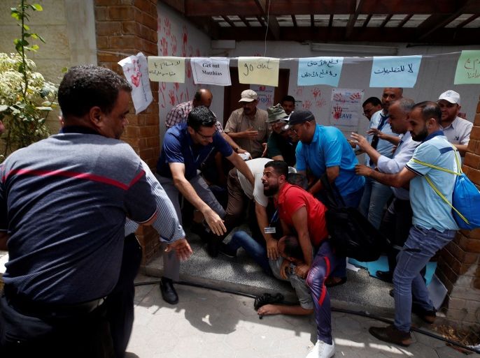 People prevent a Palestinian UNRWA employee from setting himself on fire during a protest against jobs termination by UNRWA inside its headquarters in Gaza City July 25, 2018. REUTERS/Mohammed Salem