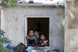 27-year-old Syrian refugee Alaa Masalmeh and her children, 5-year-old Samer and 3-year-old Mieral, look out of their home's window in Amman, Jordan, August 1, 2018. Picture taken August 1, 2018. REUTERS/Muhammad Hamed