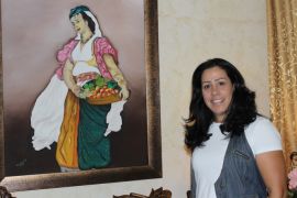 نسرين أبو غزالة أمام إحدى لوحاتها(الجزيرة نت)