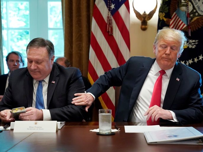 U.S. President Donald Trump pats U.S. Secretary of State Mike Pompeo on the arm after Pompeo read a prayer at the start of a cabinet meeting at the White House in Washington, U.S., August 16, 2018. REUTERS/Kevin Lamarque