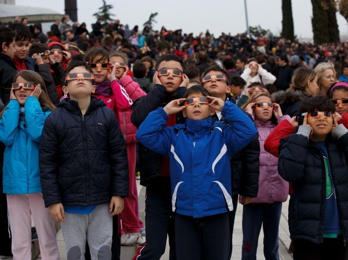 MADRID, SPAIN - MARCH 20: Children use special glasses to look into the sky during a partial solar eclipse outside the Planetario on March 20, 2015 in Madrid, Spain. In Madrid the moon was scheduled to cover approximately 65 percent of the sun for a short period starting at approximately 9:05am. (Photo by Pablo Blazquez Dominguez/Getty Images)