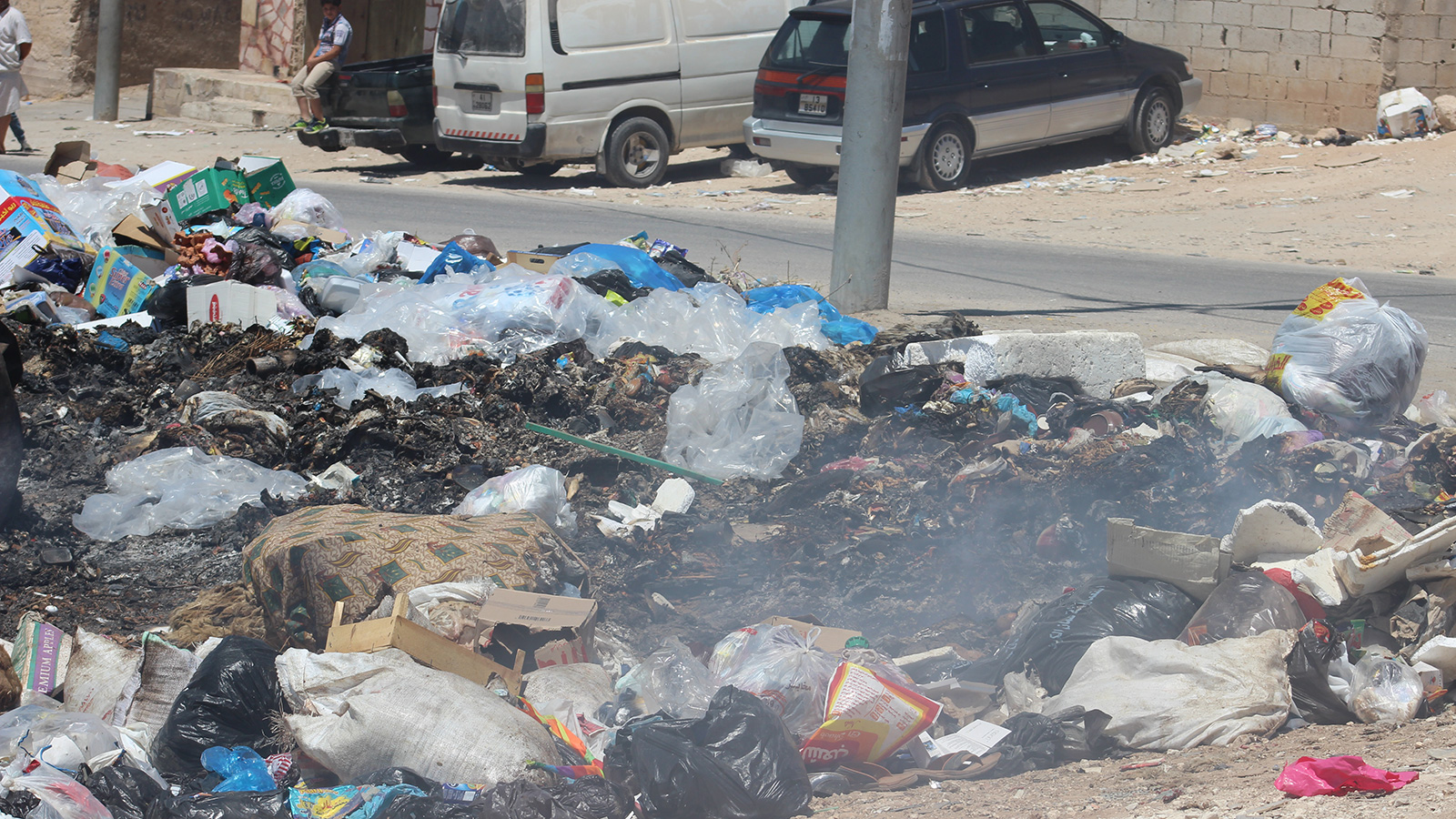 ‪أكوام من النفايات تغطي مساحات في سوق مخيم البقعة‬ (الجزيرة)