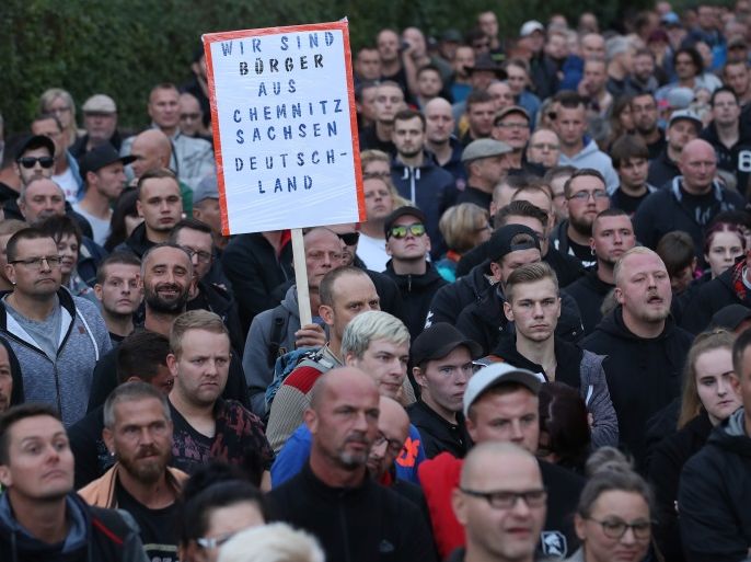 CHEMNITZ, GERMANY - AUGUST 30: Right-wing supporters, including one holding a sign that reads: 'We are citizens of Chemnitz, Saxony, Germany' gather otside CFC stadium to protest against Saxony Governor Michael Kretschmer, who was holding a dialogue with locals inside, on August 30, 2018 in Chemnitz, Germany. Chemnitz has witnessed large-scale xenophobic, right-wing protests in recent days following the suspected murder of a German man by refugees, one from Syria and