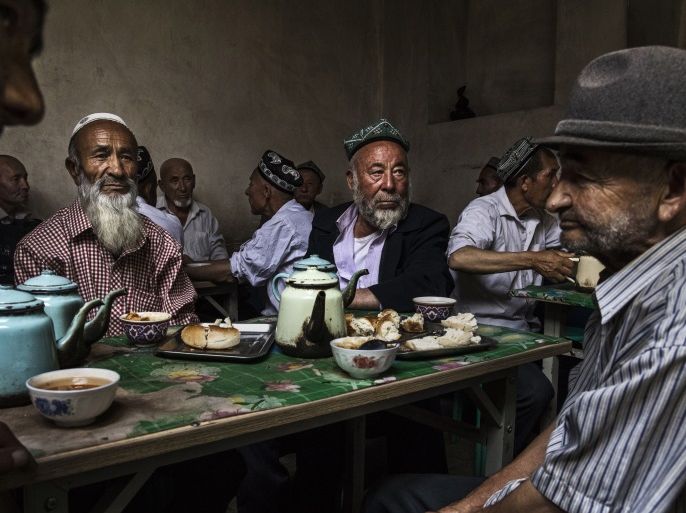 KASHGAR, CHINA - JULY 1: Ethnic Uyghur men talk as they meet at a teahouse on July 1, 2017 in the old town of Kashgar, in the far western Xinjiang province, China. Kashgar has long been considered the cultural heart of Xinjiang for the province's nearly 10 million Muslim Uyghurs. At an historic crossroads linking China to Asia, the Middle East, and Europe, the city has changed under Chinese rule with government development, unofficial Han Chinese settlement to the w