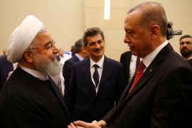 Turkish President Tayyip Erdogan chats with his Iranian counterpart Hassan Rouhani during an extraordinary meeting of the Organisation of Islamic Cooperation (OIC) in Istanbul, Turkey May 18, 2018. Kayhan Ozer/Pool via Reuters