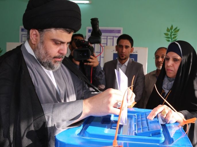 Moqtada al-Sadr, the leader of Iraq's Sadrist movement, prepares to cast his ballot for the Iraqi legislative election at a polling station in Najaf, southern Iraq, 30 April 2014