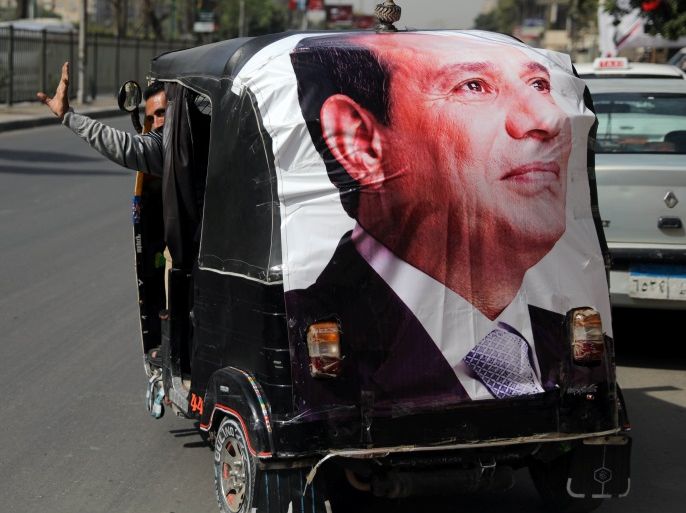 A man gestures as he rides a motorized vehicle showing a poster of Egyptian President Abdel Fattah al-Sisi during the second day of the presidential election in Cairo, Egypt, March 27, 2018. REUTERS/Ammar Awad
