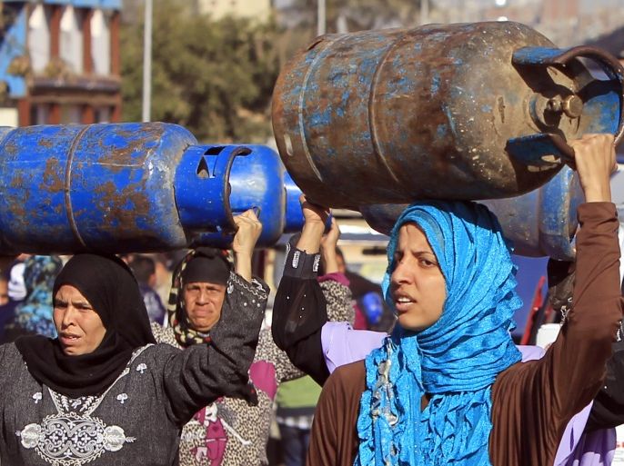Women carry gas cylinders to be refilled at a distribution point in Cairo January 19, 2015. Egypt is going through its worst energy crisis in decades and is seeking fresh sources of natural gas, which powers most of its homes and factories. REUTERS/Mohamed Abd El Ghany (EGYPT - Tags: ENERGY SOCIETY BUSINESS COMMODITIES POLITICS)