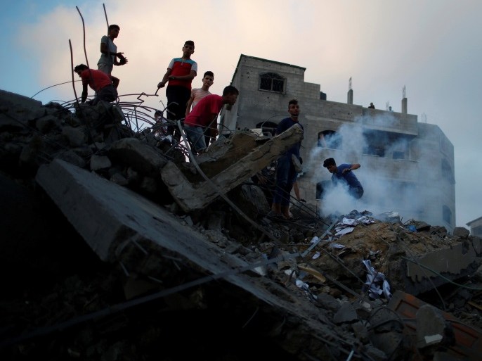 Palestinians gather on the remains of a building after it was bombed by an Israeli aircraft, in Gaza City August 9, 2018. REUTERS/Mohammed Salem