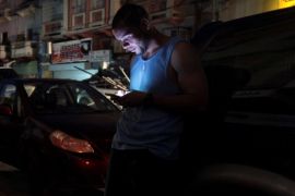 A man uses his cellphone on the street during a blackout after the area was hit by Hurricane Maria in San Juan, Puerto Rico September 25, 2017. REUTERS/Alvin Baez