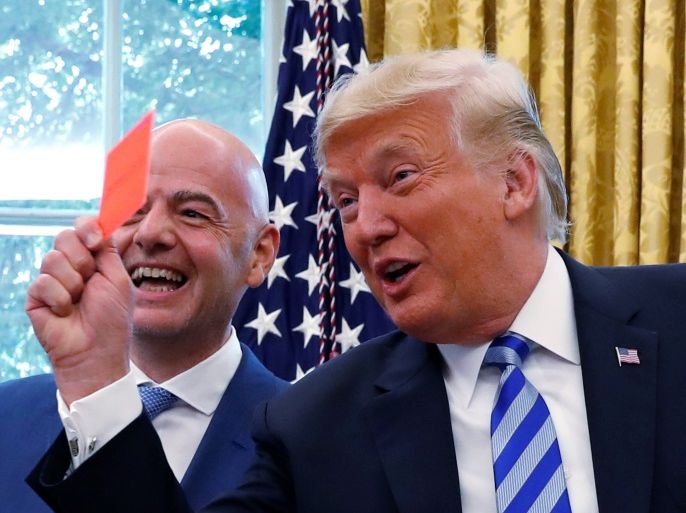 U.S. President Donald Trump holds up a red card as he meets with FIFA President Gianni Infantino in the Oval Office of the White House in Washington, U.S., August 28, 2018. REUTERS/Leah Millis