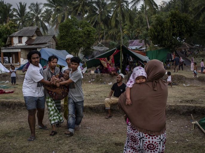 LOMBOK, INDONESIA - AUGUST 07: Indonesians carrying an elderly woman at a temporary shelter in Pemenang on August 7, 2018 in Lombok Island, Indonesia. Nearly 100 people have been confirmed dead after a 6.9-magnitude earthquake hit the Indonesian island, Lombok, and neighbouring Bali which left at least 20,000 people homeless. Based on reports, officials believe that the death toll may rise with aftershocks expected to rattle the area and aid agencies say their priority