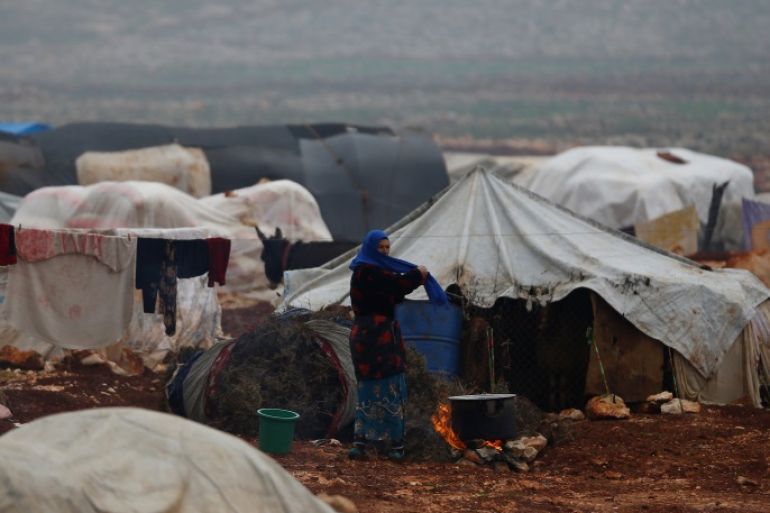 A displaced Syrian woman stands outside of her tent at Kelbit refugee camp, near the Syrian-Turkish border, in Idlib province, Syria January 17, 2018. Picture taken January 17, 2018. REUTERS/Osman Orsal