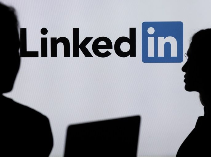 Digital Applications- - ANKARA, TURKEY - JULY 18 : Silhouettes of a people are seen in front of the logo of social networking application LinkedIn in Ankara, Turkey on July 18, 2018.