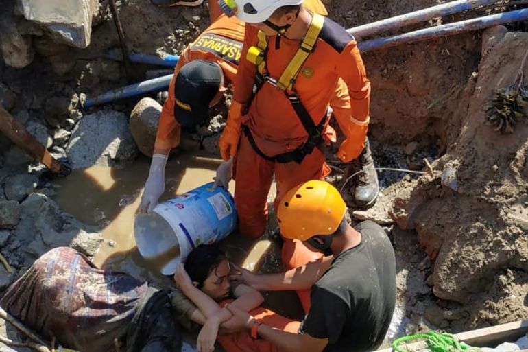 Search and rescue workers help rescue a person trapped in rubble following an earthquake and tsunami in Palu, Central Sulawesi, Indonesia September 30, 2018 in this photo taken by Antara Foto. Antara Foto/Darwin Fatir/via REUTERS. ATTENTION EDITORS - THIS IMAGE WAS PROVIDED BY A THIRD PARTY. MANDATORY CREDIT. INDONESIA OUT.