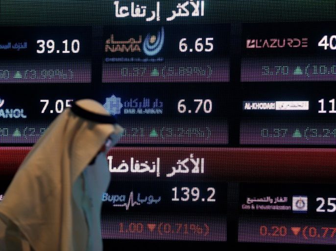 An investor walks past a screen displaying stock information at the Saudi Stock Exchange (Tadawul) in Riyadh, Saudi Arabia June 29, 2016. REUTERS/Faisal Al Nasser