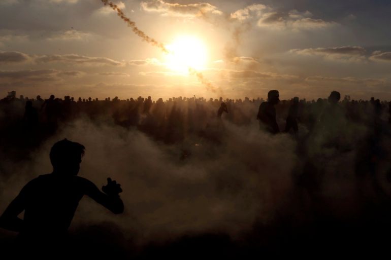 Palestinians run from tear gas during a protest calling for lifting the Israeli blockade on Gaza and demanding the right to return to their homeland, at the Israel-Gaza border fence, in the southern Gaza Strip September 21, 2018. REUTERS/Ibraheem Abu Mustafa TPX IMAGES OF THE DAY