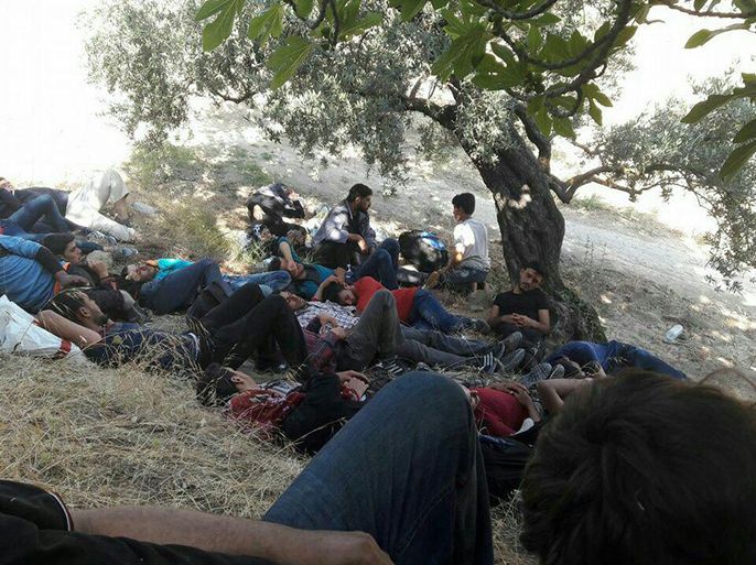 شباب سوريون يأخذون قسطا من الراحة خلال محاولتهم عبور الحدود إلى تركيا