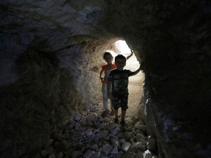 Children walk in a makeshift shelter in an underground cave in Idlib, Syria September 3, 2018. Picture taken September 3, 2018. REUTERS/Khalil Ashawi