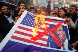 People burn a sign depicting a U.S. flag and a picture of U.S. President Donald Trump as they take part in an anti-U.S. rally in Peshawar, Pakistan, January 5, 2018. REUTERS/Fayaz Aziz