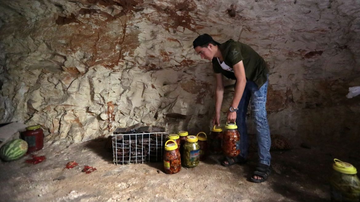 A man holds pickled vegetables in an underground cave in Idlib, Syria September 3, 2018. Picture taken September 3, 2018. REUTERS/Khalil Ashawi