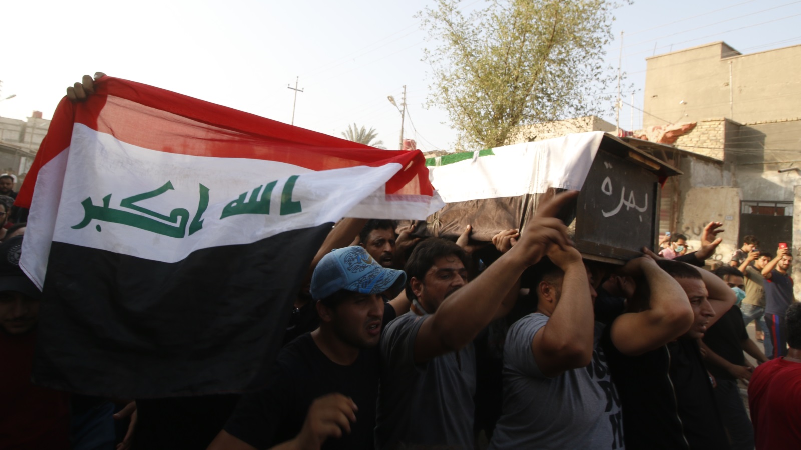 ‪‬ مواطنون في البصرة أثناء تشييع أحد شهداء المظاهرات(الأناضول)