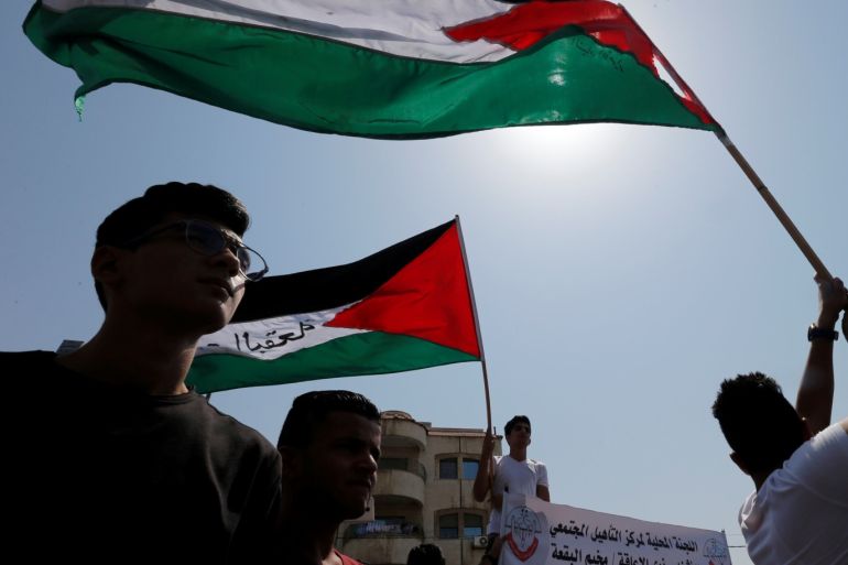 Palestinian refugees hold Palestinian flags and chant slogans during a protest in front of UNRWA office in Amman, September 2, 2018. REUTERS/Muhammad Hamed