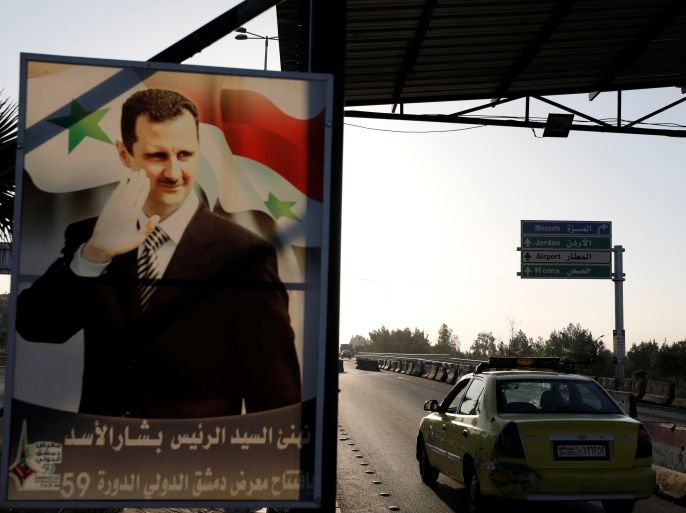 A poster of Syrian President Bashar al-Assad is seen on the main road to the airport in Damascus, Syria April 14, 2018. REUTERS/Omar Sanadiki