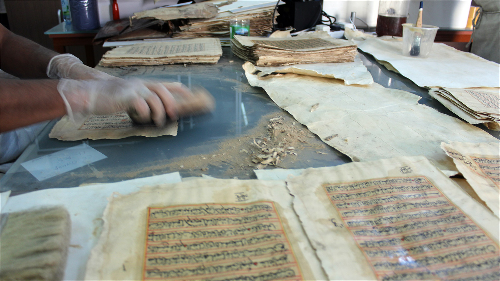 تنظيف المخطوطات في بيت الترميم العماني(الجزيرة نت)