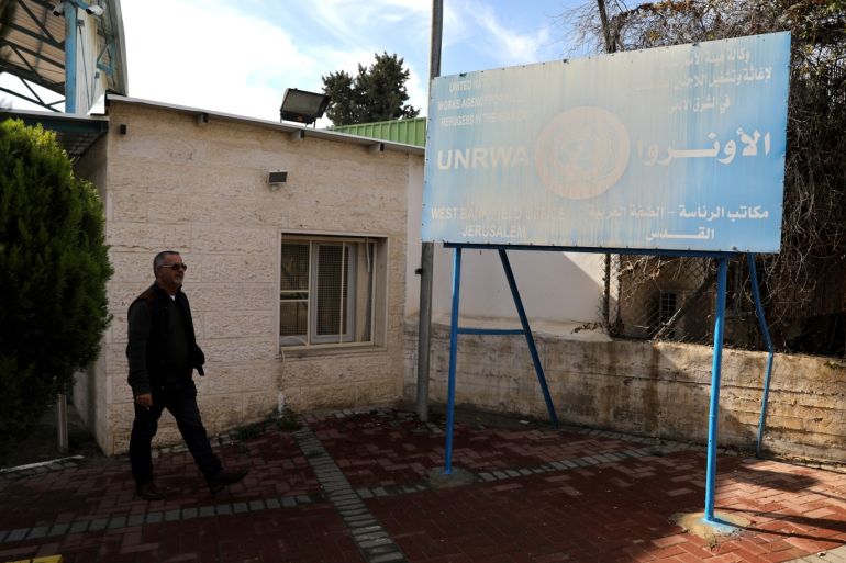 A man walks next to a sign at the entrance to the U.N. Relief and Works Agency (UNRWA) West Bank Field Office complex in East Jerusalem January 3, 2018. REUTERS/Ammar Awad