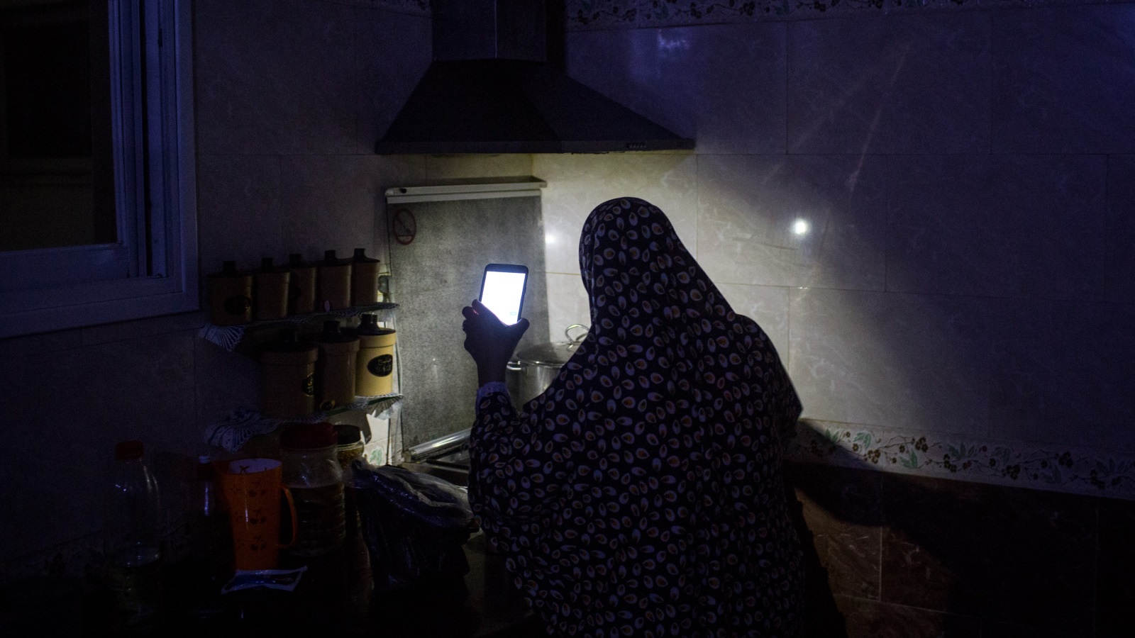  سيدة تطبخ على ضوء هاتفها في غزة