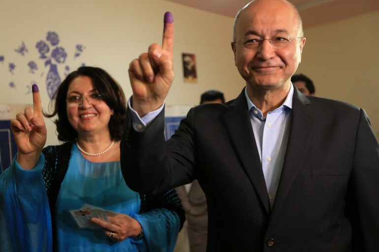 Barham Salih, Former Prime Minister of Iraq's Kurdistan Regional Government and Head of the Coalition for Democracy and Justice with his wife show their ink-stained fingers after casting their votes at a polling station during the parliamentary election in Sulaimaniyah, Iraq May 12, 2018. REUTERS/Ari Jalal