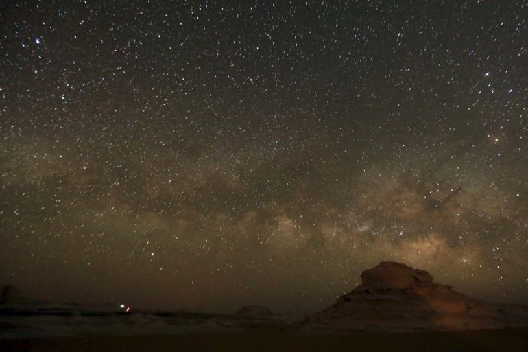 The 'Milky Way' is seen in the night sky over rocks in the White Desert north of the Farafra Oasis southwest of Cairo May 15, 2015. The White Desert, about 500 km southwest of the Egyptian capital Cairo, features limestone and chalk forms strangely shaped by the wind and sand, a terrain that gains in intensity when illuminated by the moon. Slightly to the north lies the Black Desert, given its name by the volcanic rock dolerite, similar to basalt. Four-by-four and tre