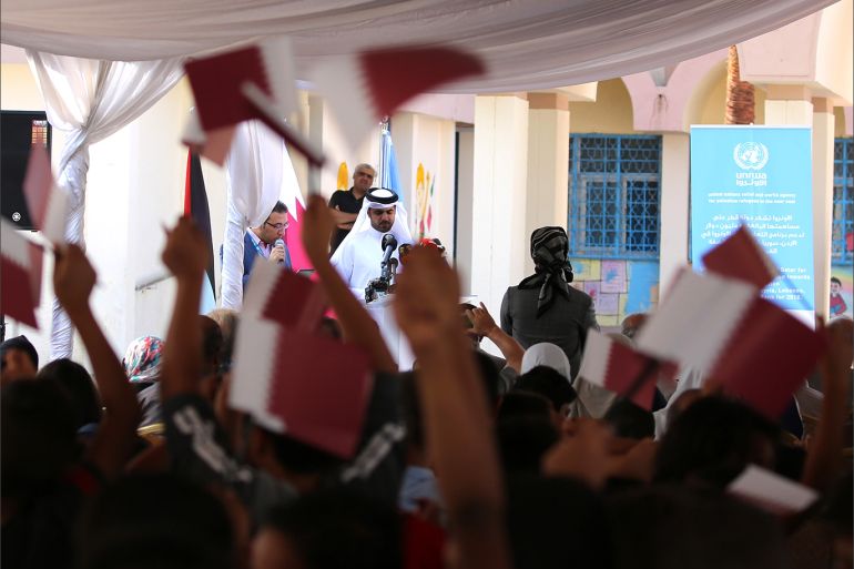 epa07065744 Palestinian refugee school boys wave the Qatari national flag during the speech of the Director of the Qatar Fund for Development Khalifa Bin Jassim AL-Kuwari (C, background) at a Back to School ceremony at the Al-Baqa'a Elementary School for Boys, Al-Baqa'a Palestinian Refugee Camp, about 20 kilometers north of Amman, Jordan, 03 October 2018. The United Nations Relief and Works Agency (UNRWA) for Palestine Refugees announced on 27 September that it has received pledges of some 118 million USD in new funding to help overcome the crisis triggered by the cuts in US funding earlier this year. UNRWA's Jordan Operations Director Roger Davies renewed his thanks to the state of Qatar and the Qatar Fund for Development for its unprecedented support to the UN agency with some 50 million USD donation. EPA-EFE/AMEL PAIN