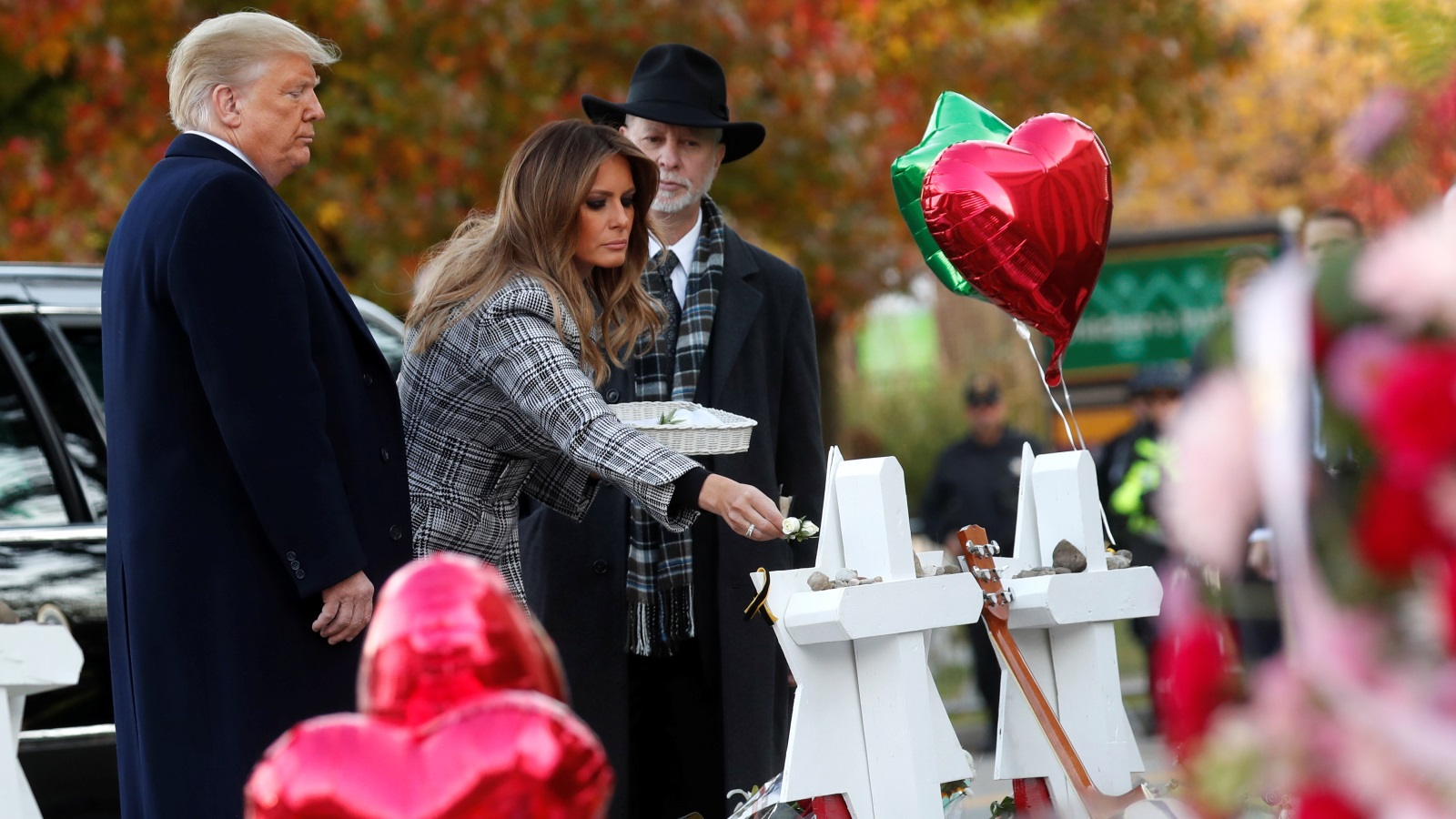‪ترامب وزوجته ميلانيا مع حاخام الكنيس في موقع مخصص للترحم على الضحايا‬ (رويترز)