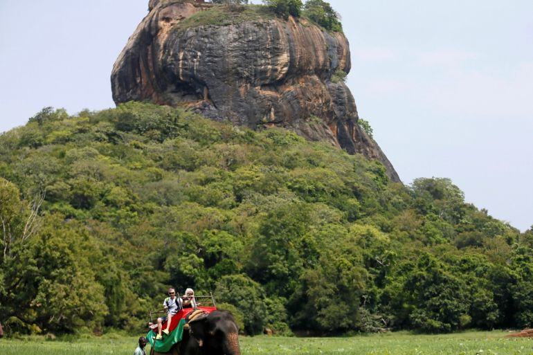 Tourists travel on top an elephant passing the UNESCO listed World Heritage Site Sigiriya Rock Fortress in Sigiriya, Sri Lanka October 11, 2018. REUTERS/Dinuka Liyanawatte