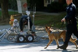 Law enforcement personnel monitor activity with a dog and operate a bomb disposal robot outside a post office which had been evacuated in Wilmington, Delaware, U.S. October 25, 2018. REUTERS/Mark Makela