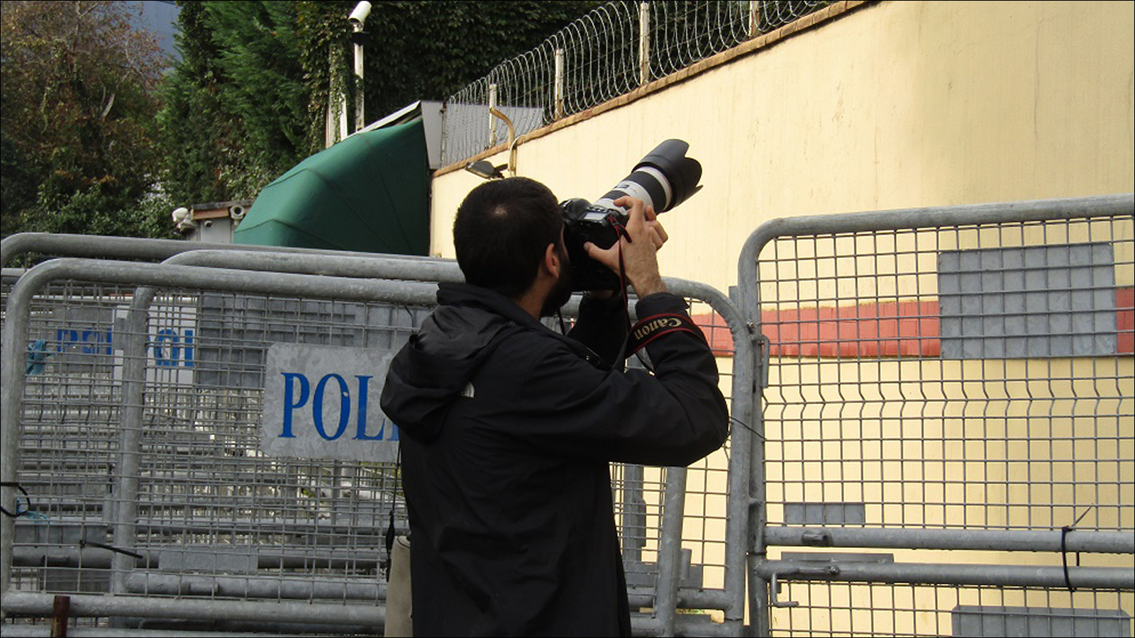 ‪أحد الصحفيين يحاول التقاط صورة لداخل القنصلية السعودية‬ (الجزيرة نت)