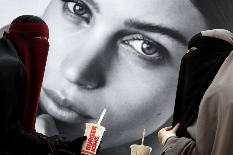 Ayah (L), 37, and Aisha, 18, wearers of the niqab and members of the group Kvinder I Dialog (Women In Dialogue), sit in a shopping center near Copenhagen, Denmark, July 19, 2018. REUTERS/Andrew Kelly SEARCH