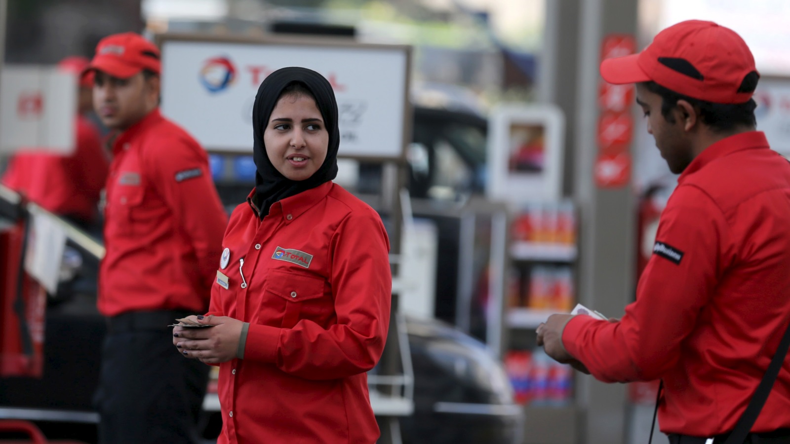 شابة مصرية تعمل في محطة وقود بالقاهرة (رويترز)