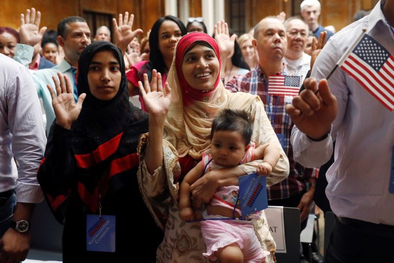 New citizens stand during the Pledge of Allegiance at the U.S. Citizenship and Immigration Services (USCIS) naturalization ceremony at the New York Public Library in Manhattan, New York, U.S., July 3, 2018. REUTERS/Shannon Stapleton