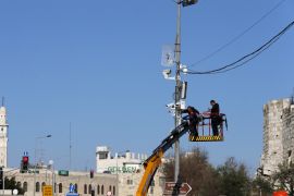 Workers install security cameras on a street pole near Damascus Gate in Jerusalem's Old City February 15, 2016. REUTERS/Ammar Awad