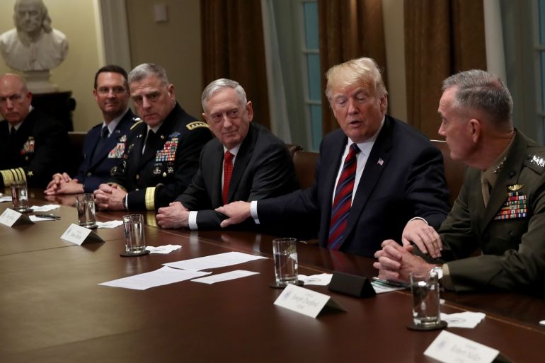 WASHINGTON, DC - OCTOBER 23: U.S. President Donald Trump reaches out to touch the arms of Chairman of the Joint Chiefs of Staff Joseph Dunford (R) and U.S. Defense Secretary Jim Mattis (C) while delivering remarks during a meeting with military leaders in the Cabinet Room on October 23, 2018 in Washington, DC. Trump discussed a range of issues while press were in the room including current relations with Saudi Arabia, and the use of the U.S. military in protecting the b