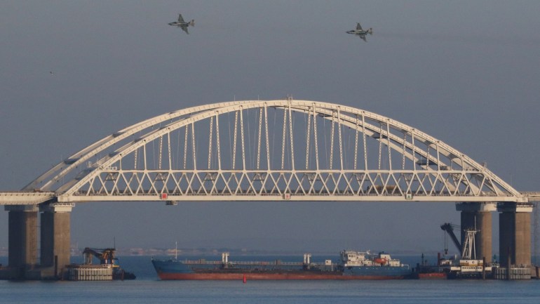 Russian jet fighters fly over a bridge connecting the Russian mainland with the Crimean Peninsula with a cargo ship beneath it after three Ukrainian navy vessels were stopped by Russia from entering the Sea of Azov via the Kerch Strait in the Black Sea, Crimea November 25, 2018. REUTERS/Pavel Rebrov TPX IMAGES OF THE DAY
